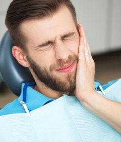 A patient holding his mouth in pain.