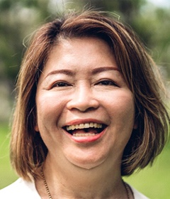 person smiling and strolling through a park