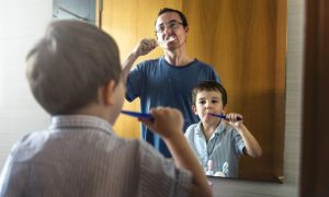 Father and son brushing to protect their immune systems.