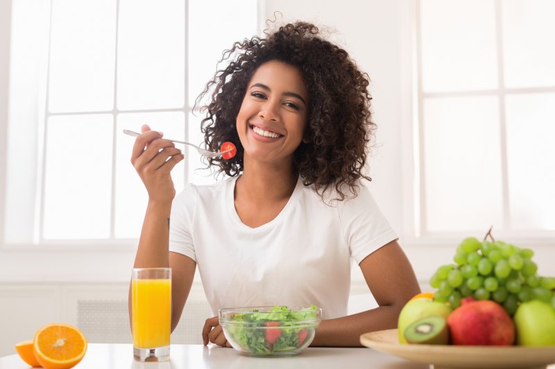 young woman smiling and eating healthy foods