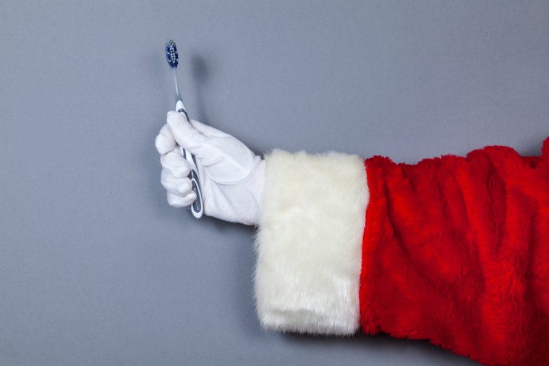 person in a Santa coat holding a toothbrush