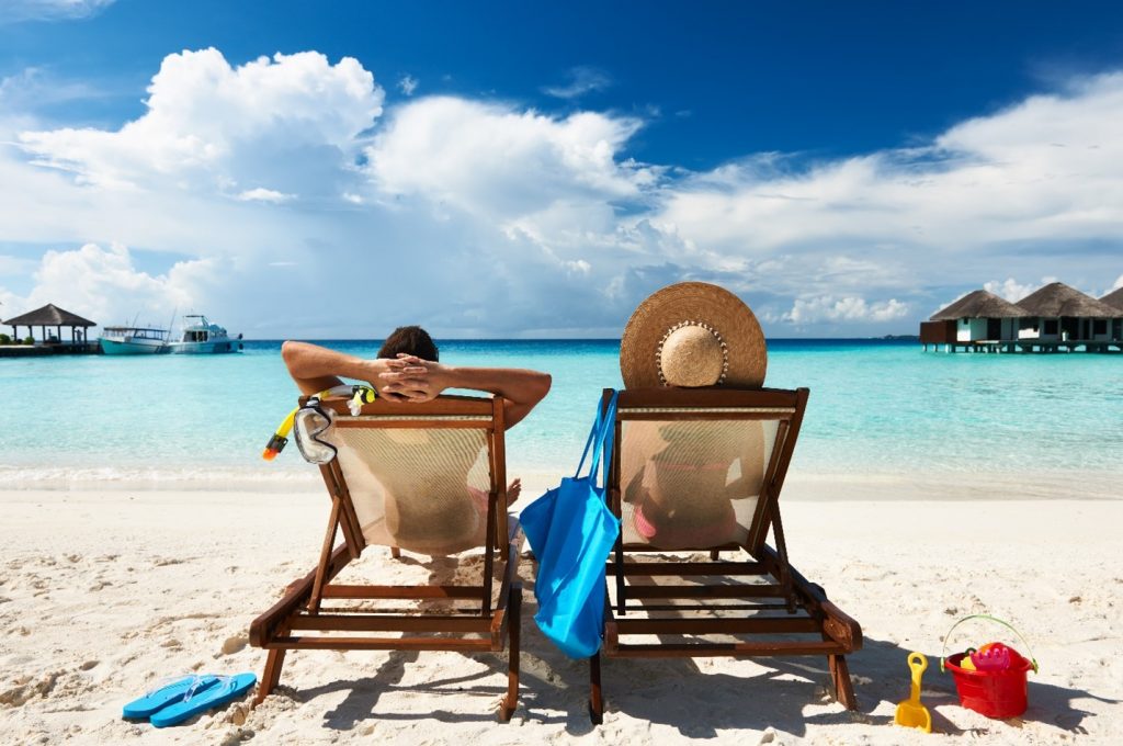 Two people relaxing on the beach during summer.