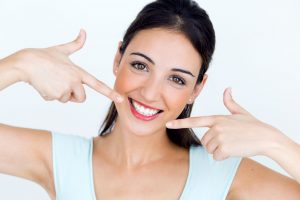 woman pointing to her bright smile 