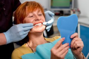 a woman getting her high-quality dental implants placed at the dentist