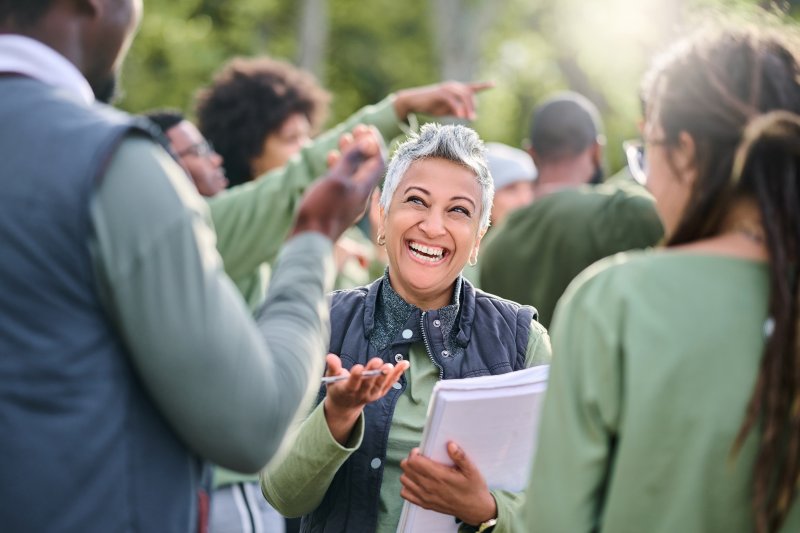 a woman smiling while socializing with others 