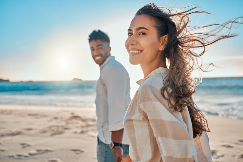 a woman smiling at the beach during summer vacation