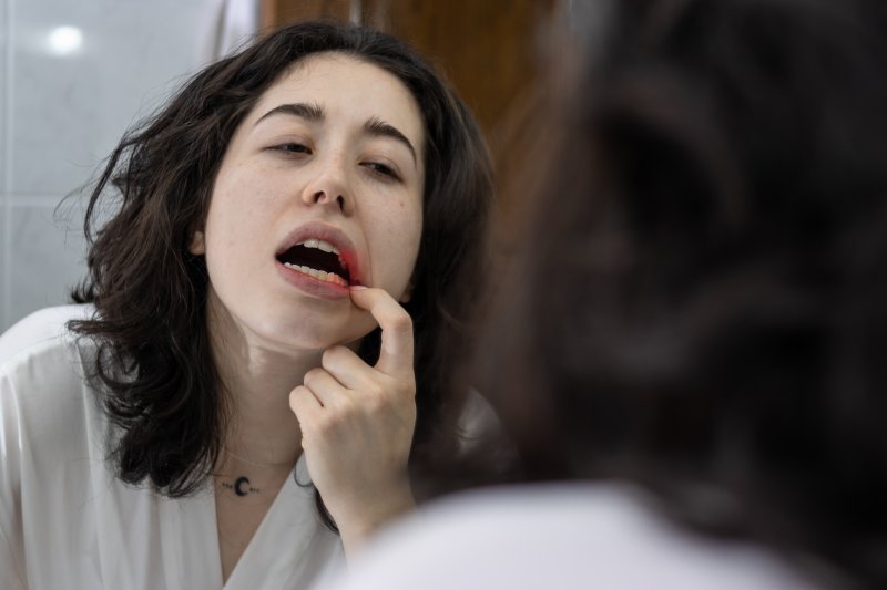 Patient looking at their gums in the mirror